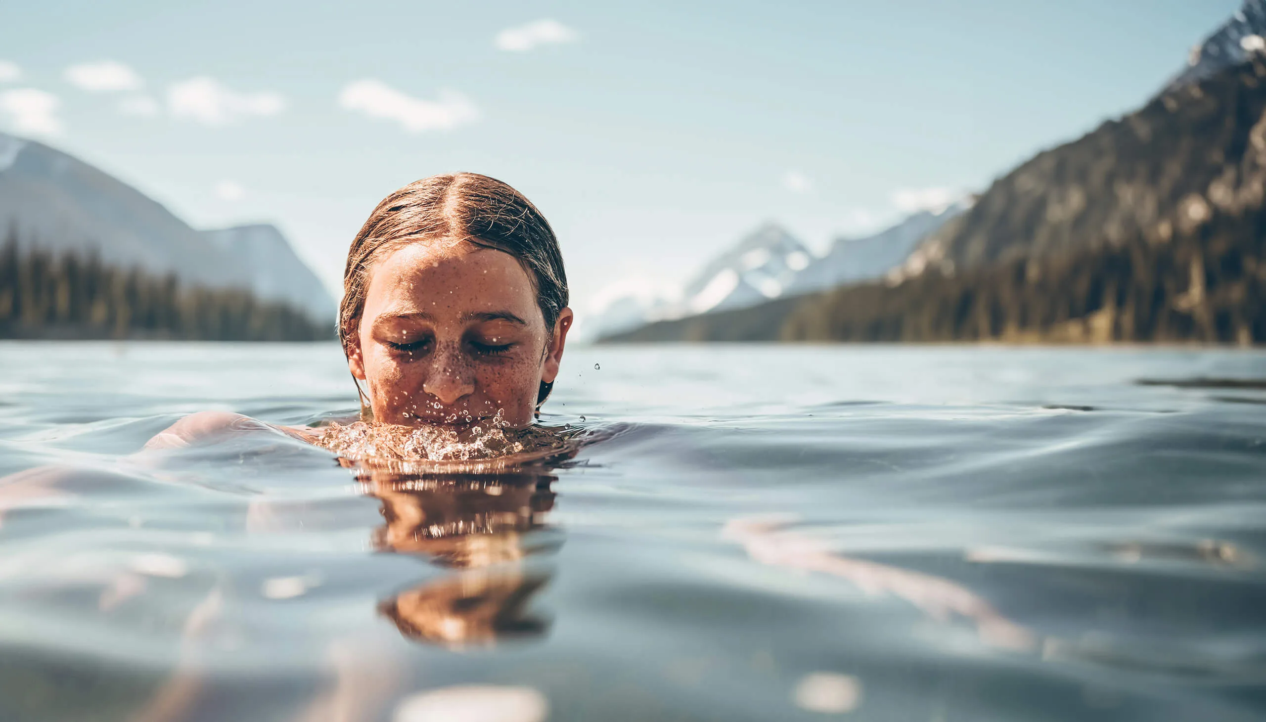 Kind genie&szlig;t den Badeurlaub im glasklaren See in Flachauwinkl mit traumhafter Bergkulisse in &Ouml;sterreich