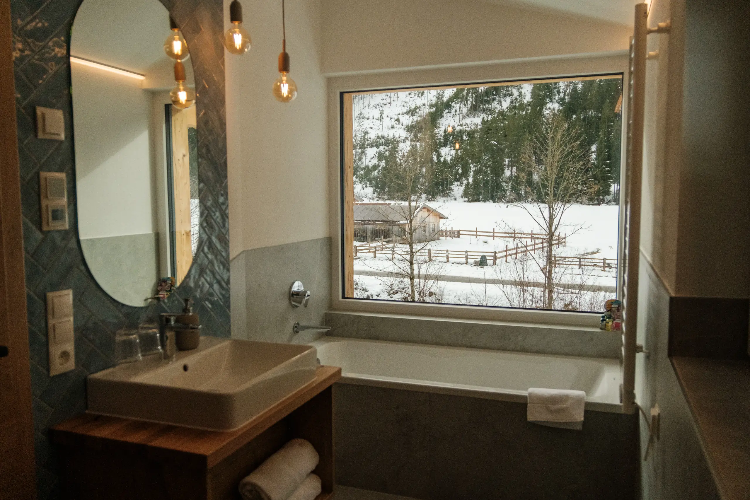 Badezimmer mit Badewanne und Blick auf verschneite Landschaft