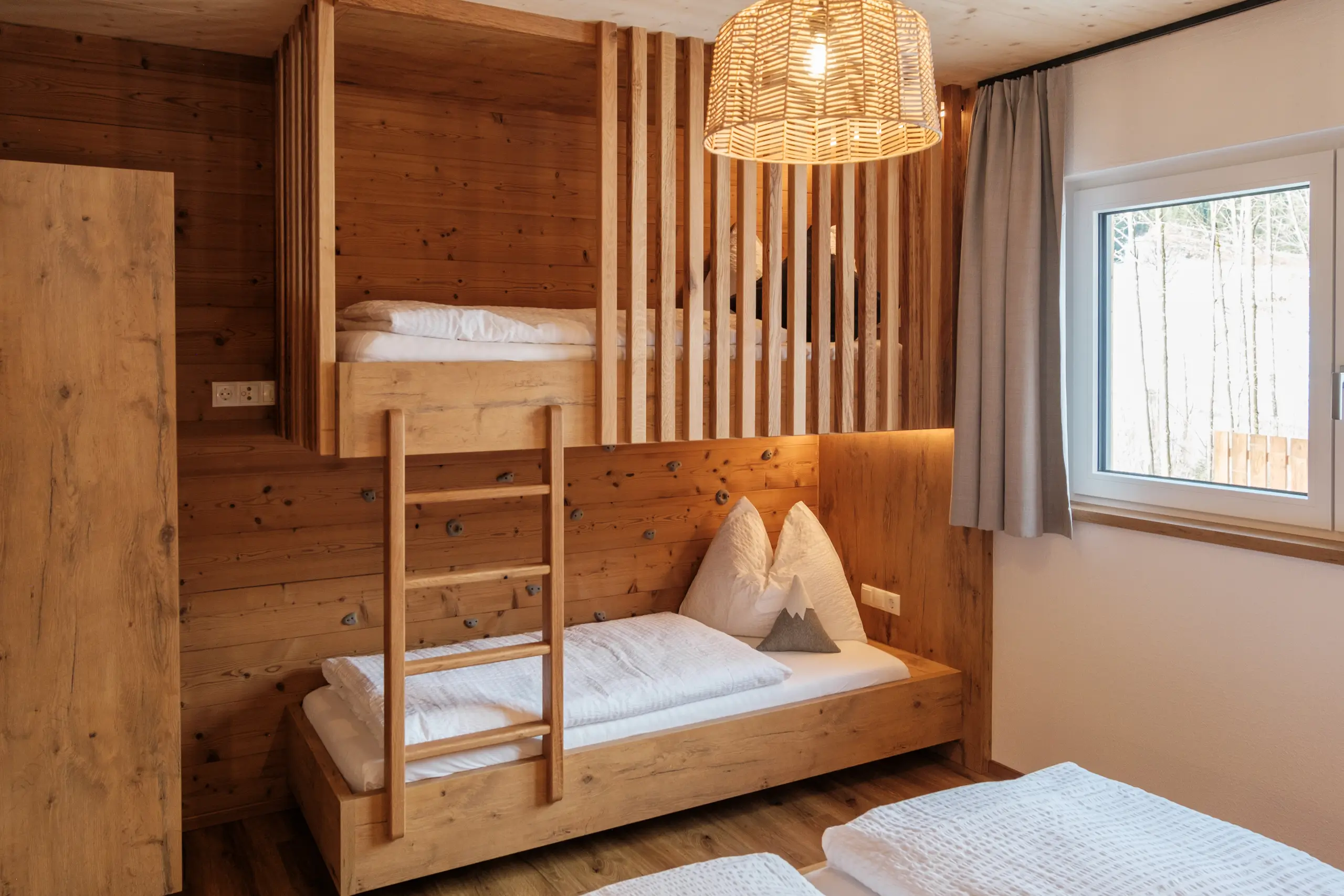 Holzbett mit Etagenbett und Leiter in einem gemütlichen Zimmer.