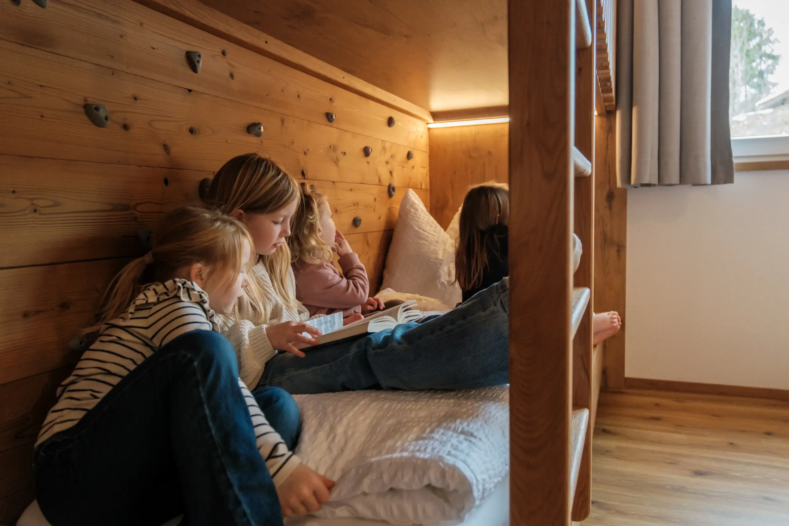 Mädchen lesen Buch im hölzernen Etagenbett. Kinderzimmer-Szene.