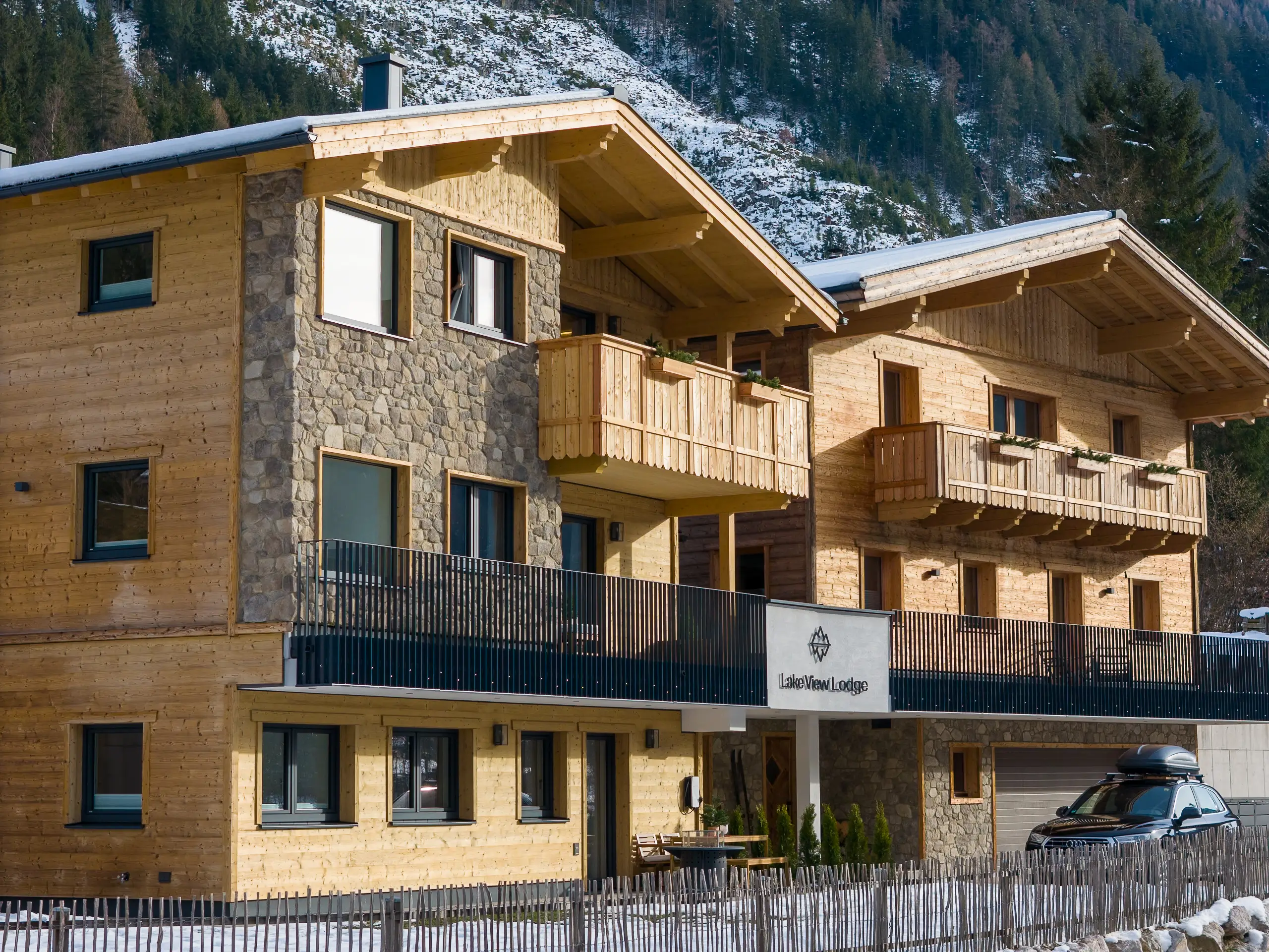 Lake View Lodge Gebäude mit Holzfassade und Steinmauerwerk in den Bergen.